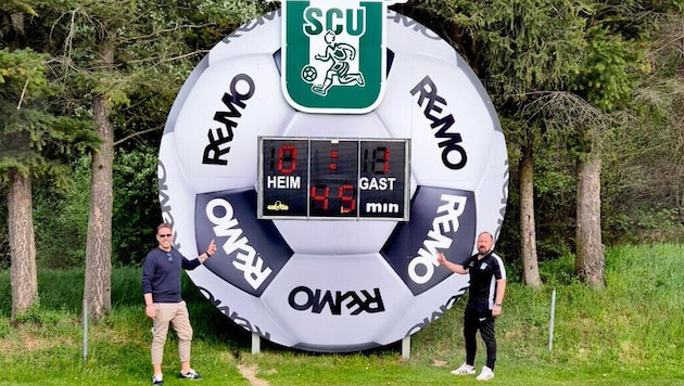 Jürgen Rochla und Otto Kainz (von links) freuen sich über den riesigen, fünf Meter großen Fußball, der jetzt die neue Anzeigetafel in der Arena Gars darstellt.