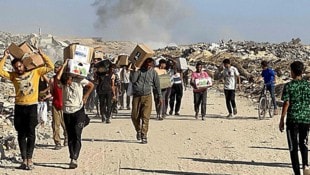 Palästinenserinnen und Palästinenser mit Hilfslieferungen im Gazastreifen (Archivbild)