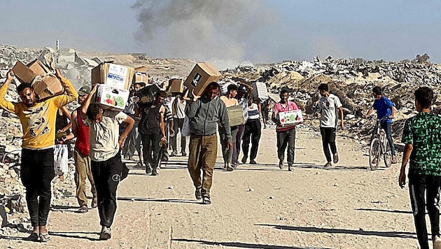 Palästinenser mit Essenspaketen im Gazastreifen (Symbolbild)
