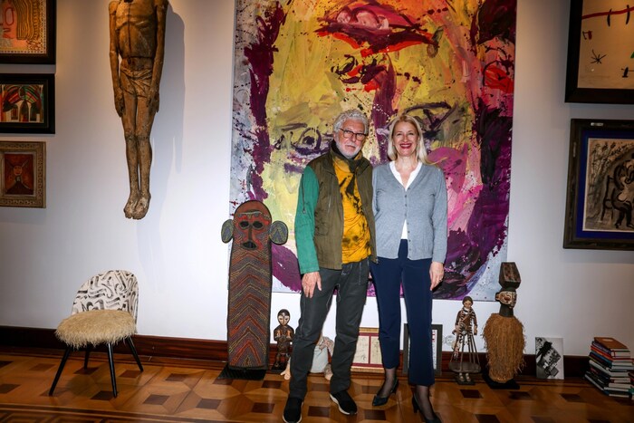 Inmitten von Kunstwerken posiert der Visionär mit Claudia Stöckl