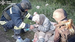 Rettungskräfte versorgen eine verletzte Frau nach einem russischen Luftangriff in der Region Sumy. (Bild: AP/Ukrainian Emergency Service)