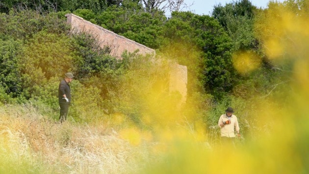 Polizisten durchqueren das unwegsame Gelände rund um ein verlassenes Haus. (Bild: AP/Joao Matos) Polizisten durchqueren das unwegsame Gelände rund um ein verlassenes Haus. (Bild: AP/Joao Matos)