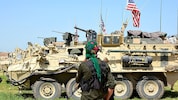 Archivbild aus dem Jahr 2017: Ein kurdischer Kämpfer im Nordosten Syriens in der Nähe von gepanzerten US-Militärfahrzeugen (Bild: EPA/YOUSSEF RABIE YOUSSEF)