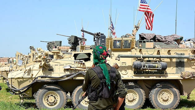 Archivbild aus dem Jahr 2017: Ein kurdischer Kämpfer im Nordosten Syriens in der Nähe von gepanzerten US-Militärfahrzeugen