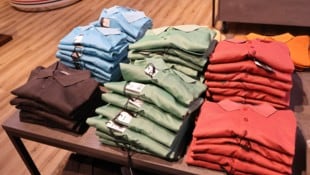 Das Mädchen hat von zahlreichen Kleidungsstücken die Etiketten entfernt und wolle sie aus dem ...