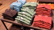 Das Mädchen hat von zahlreichen Kleidungsstücken die Etiketten entfernt und wolle sie aus dem ...