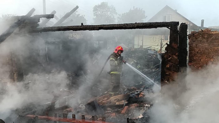 Ein Feuerwehrmann löscht nach den Drohnen-Anschlägen den Brand.