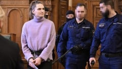 Außerhalb der Zelle werde Maja T. in Handschellen und Fußfesseln an einer Leine geführt von vier ...