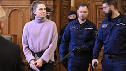Außerhalb der Zelle werde Maja T. in Handschellen und Fußfesseln an einer Leine geführt von vier ...