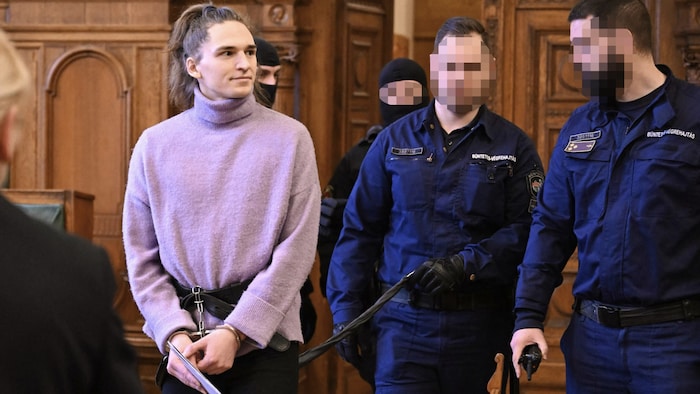Außerhalb der Zelle werde Maja T. in Handschellen und Fußfesseln an einer Leine geführt von vier ...