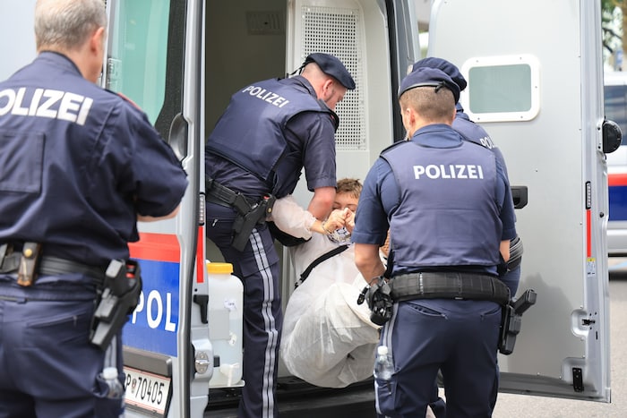 Ein Aktivist wird in ein Polizeifahrzeug verfrachtet.