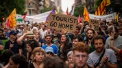 „Geh nach Hause, Tourist“ – eine Demonstrantin hält ein Schild mit eindeutiger Botschaft in den ...