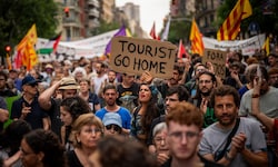 „Geh nach Hause, Tourist“ – eine Demonstrantin hält ein Schild mit eindeutiger Botschaft in den ...