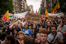 „Geh nach Hause, Tourist“ – eine Demonstrantin hält ein Schild mit eindeutiger Botschaft in den ...