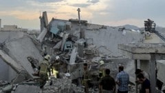 Anrainer und Einsatzkräfte nach einem israelischen Luftangriff in Teheran