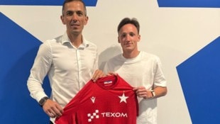Ertlthaler mit Berater Markus Peresich vor dem Vereinswappen.