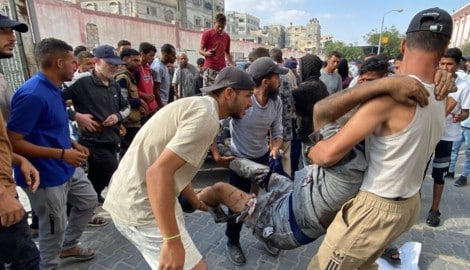Palästinenser bringen einen Mann, der während der Lebensmittelausgabe von Israelis angeschossen ...