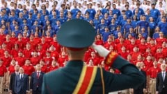 Ein russischer Soldat steht vor Aktivisten der russischen patriotischen Bewegung, die in den ...