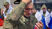 Russische Soldaten telefonieren mit Verwandten nach ihrer Freilassung im Zuge eines ...