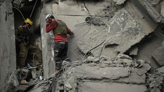 israelische Einsatzkräfte inspizieren nach einem iranischen Raketenangriff ein Wohnhaus in ...