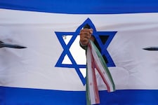 Eine iranische Faust, die eine israelische Flagge durchschlägt, bei einer Kundgebung in Teheran