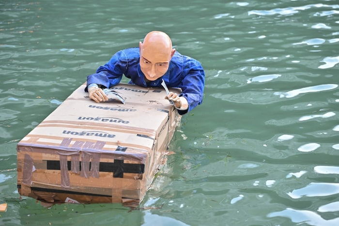 Chef auf Tour! Die Bezos-Puppe schippert im Blaumann und mit Riesenpaket durch Venedigs Kanäle.