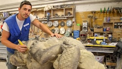 Steinmetzmeister Stefan Paulischitz, Spezialist für Denkmalpflege, säubert die Bruchstellen.