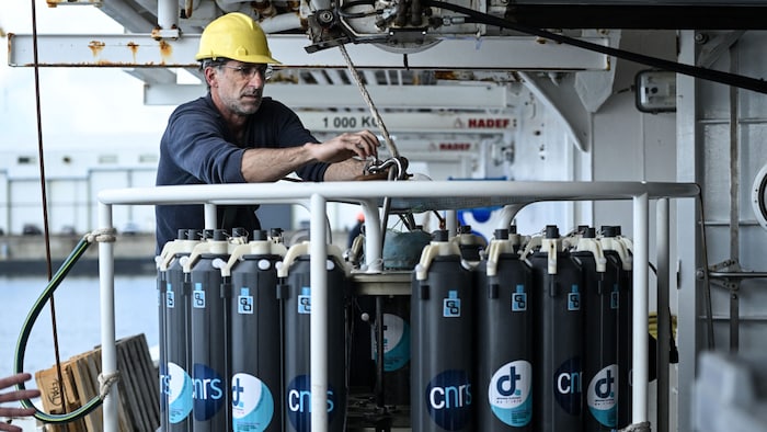 Die Forscher entnehmen Wasserproben im Umfeld der Atommüllfässer.