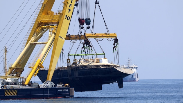 Hier wird das ehemals luxuriöse Segelschiff, das als unsinkbar angepriesen wurde, aus dem Meer ...