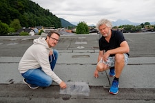 Die Bewohner Hans Huber und Bernhard Mühlbacher auf dem Dach ihres Hauses.