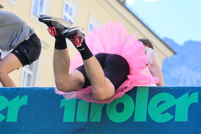 Ja wer fliegt denn da über die „Tiroler Wand“? Ein Athlet in einem pinken, kurzen Tütü.