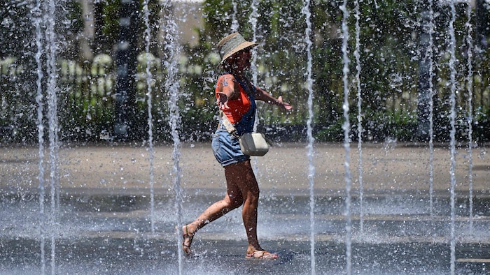 Eine Frau in Südfrankreich sucht in einem Brunnen nach Erfrischung.