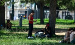 Menschen suchen in einem Park in Lissabon Zuflucht vor der Hitze.