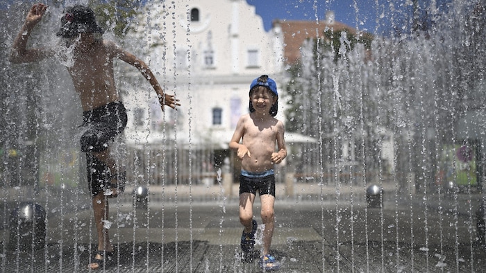 Diese Buben genießen die Springbrunnen auf dem heißen Pflaster in Tulln (NÖ).