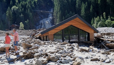 Der Sandeswasserfall im Hintergrund. Vorn ein komplett vermurtes Haus.