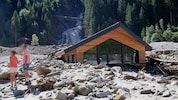 Der Sandeswasserfall im Hintergrund. Vorn ein komplett vermurtes Haus.