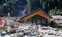 Der Sandeswasserfall im Hintergrund. Vorn ein komplett vermurtes Haus.