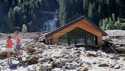 Der Sandeswasserfall im Hintergrund. Vorn ein komplett vermurtes Haus.