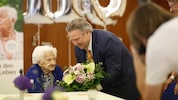 Bürgermeister Michael Ludwig (SPÖ) gratuliert mit Blumen der besonderen Jubilarin.