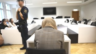 Die 30-Jährige verdeckt vor Gericht in Wien ihr Gesicht mit einem Tuch.
