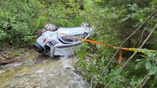 Der stark beschädigte Pkw kam seitlich im Bach zum Liegen.