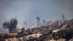 Maskierte israelische Siedler schleudern Steine auf die Häuser von dort wohnenden ...