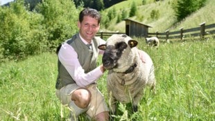 Bürgermeister Thomas Kößler mit wuscheligem Weidetier