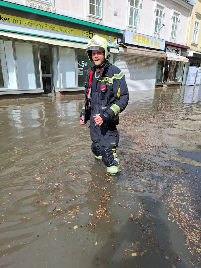 Bis zu den Knien im Wasser – Feuerwehrmann in der Wiener Neustädter Fußgängerzone.