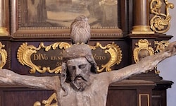 Der kleine Vogel ließ sich erschöpft auf dem Jesus-Haupt nieder.