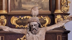 Der kleine Vogel ließ sich erschöpft auf dem Jesus-Haupt nieder.