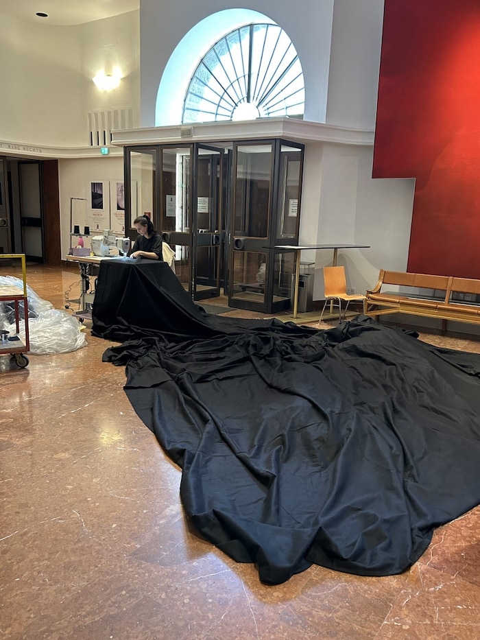 Anna Pachler von der Tapeziererei bei Näharbeiten im Foyer