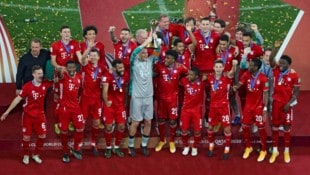 Der FC Bayern mit Kapitän Manuel Neuer (mi.) stemmt den Pokal für den Sieg im Klub-WM-Finale ...