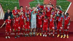 Der FC Bayern mit Kapitän Manuel Neuer (mi.) stemmt den Pokal für den Sieg im Klub-WM-Finale ...