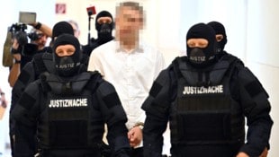Der 18-jährige angeklagte Terrorverdächtige wird schwer bewacht vorgeführt.